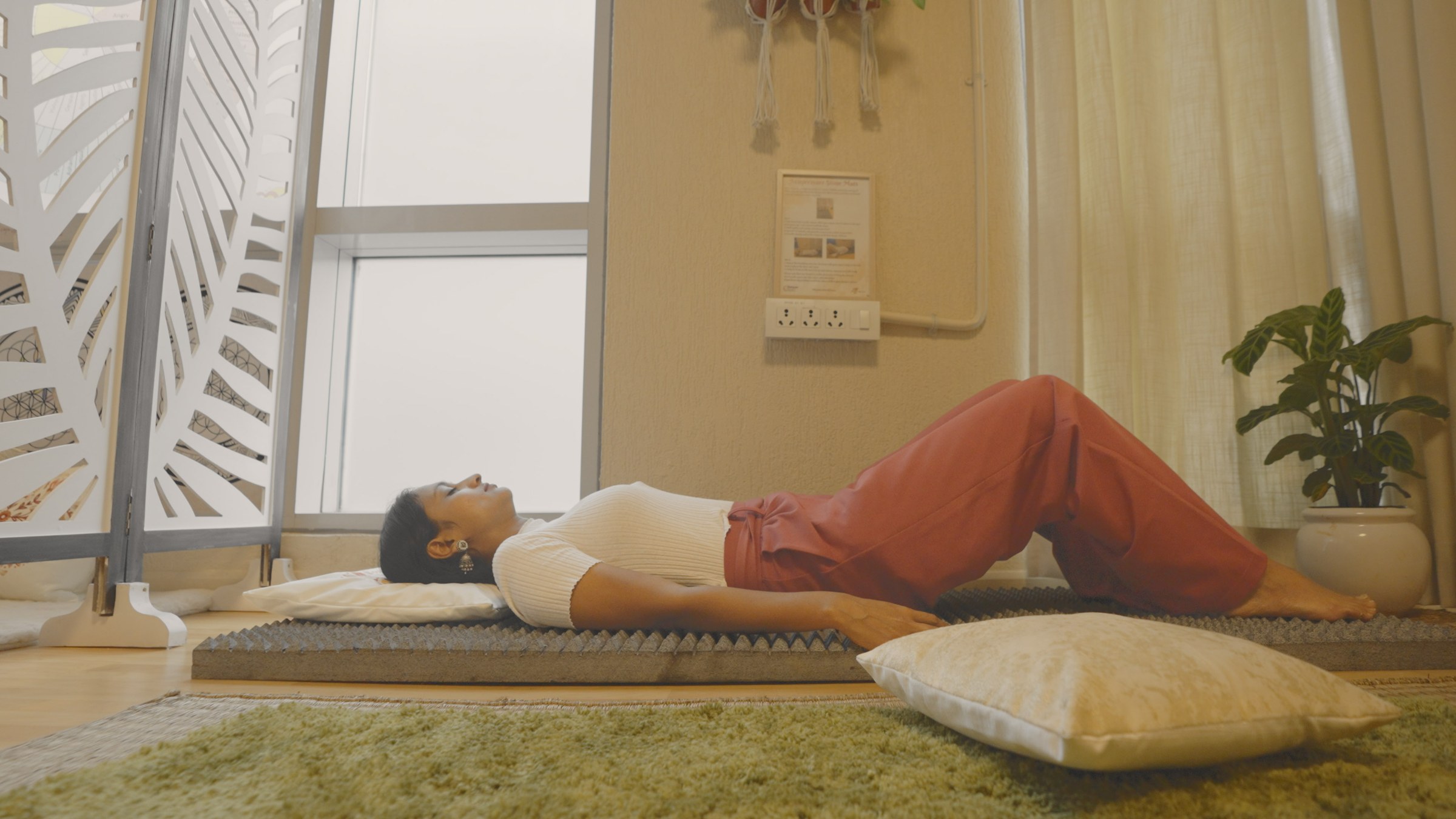 Somebody lying on a mat in the room during the working day, shoes off, nobody supervising